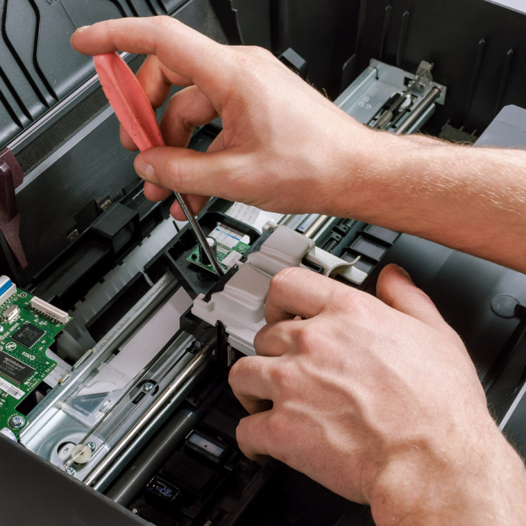 Technician performing repair on internal components of a continuous inkjet printer